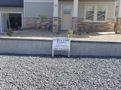 Curved Allan Block retaining wall with professional landscape grading and native plantings in Oliver BC